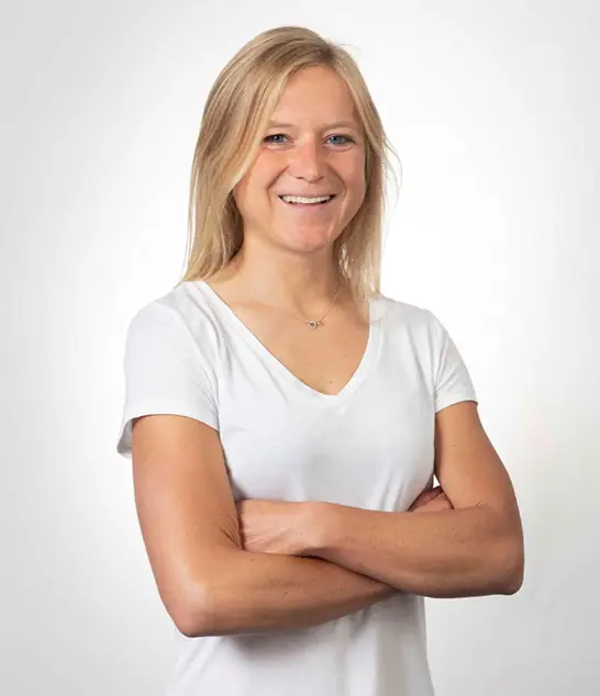Kathrin Wörle mit langen blonden Haaren im weißen T-Shirt, lächelnd - Vertriebsleitung für Ihr Massivhaus-Projekt.